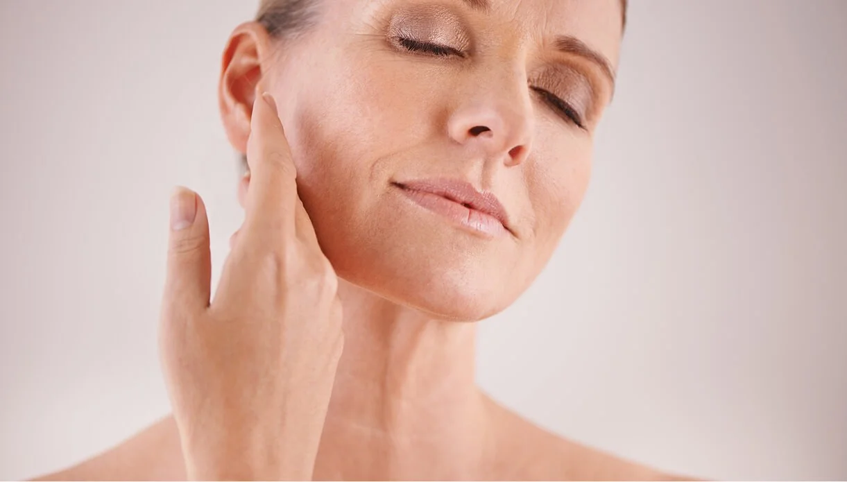 alt="A woman gently touching her jawline, illustrating the natural facial contours discussed in the rtwskin thread lift guide in Tunbridge Wells."